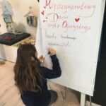 Dziewczynka pisze na tablicy kalambury językowe