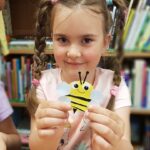 Dziewczynka prezentuje swoją pszczołę z kartonu