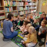 Bibliotekarka pokazuje grupie dzieci książkę