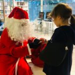 Mikołaj rozdaje prezent dziewczynce