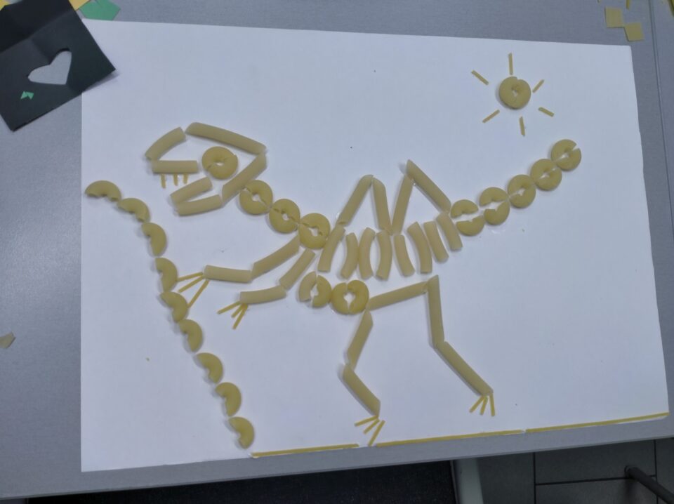 Kartka z naklejonym dinozaurem z makaronu - tyranozaura