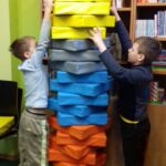 Dwaj chłopcy budują wieżę z dropsów