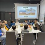 Geolog rozmawia z dziećmi, na ekranie wyświetla budowę płaszcza Ziemi