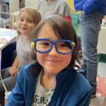 Dziewczynka prezentuje oprawy okularowe wykonane techniką 3D