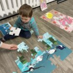 Chłopiec bawi w układanie dużych puzzli