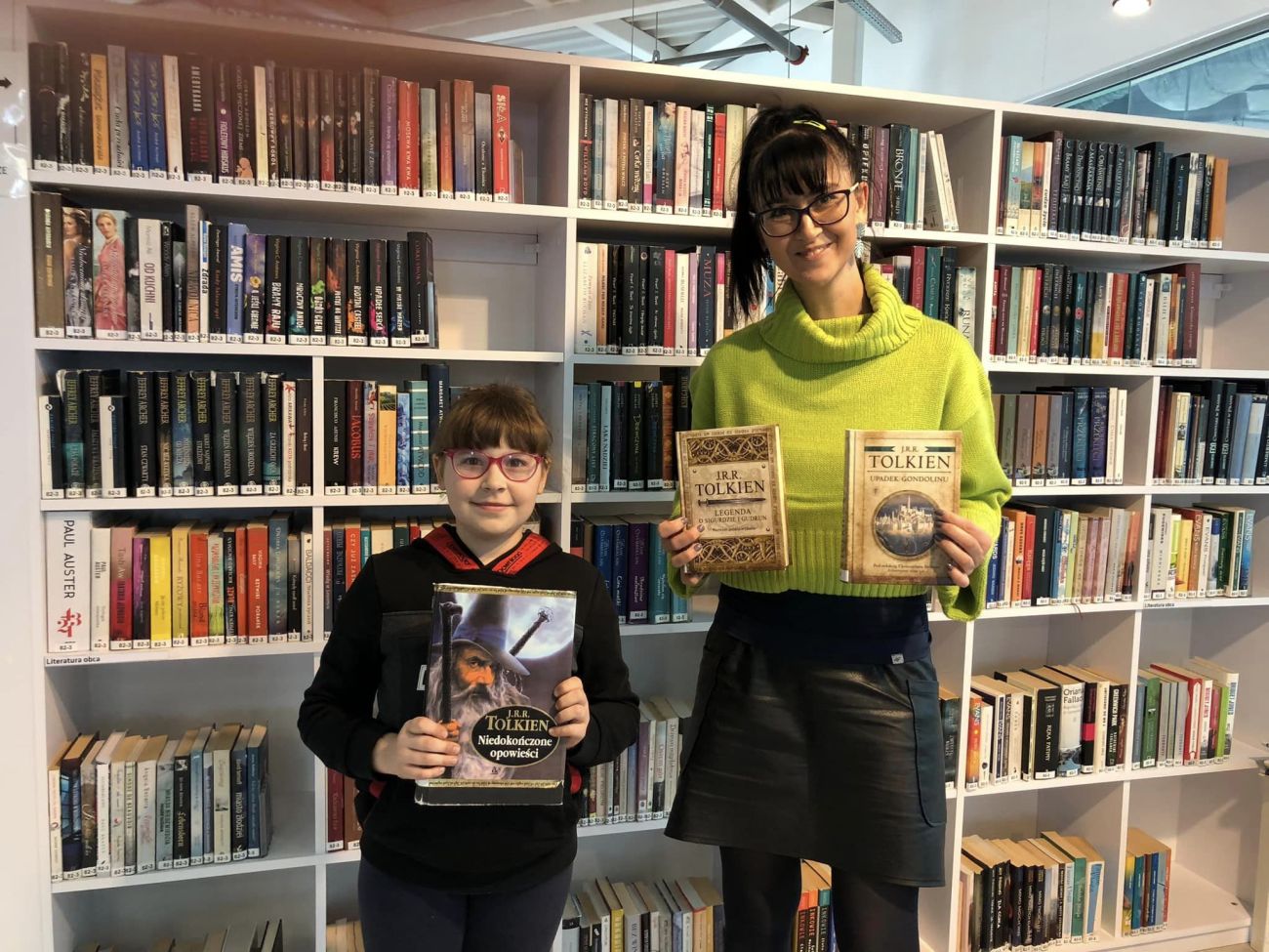 Czytelniczka z bibliotekarką prezentują książki Tolkiena