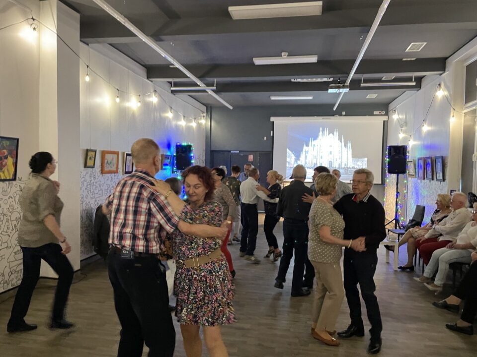 Widok ogólny na salę z tańczącymi seniorami