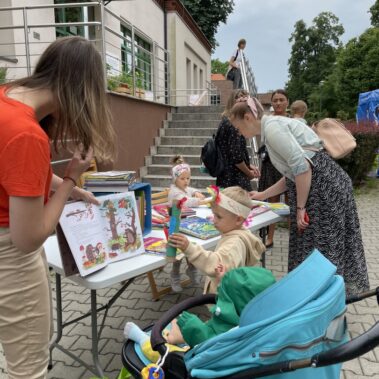 Głośne czytanie dla małego dziecka w wózku w towarzystwie małego Indianina.