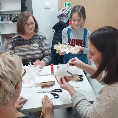 Uczestniczki przy pracy, dziewczynka już rozkłada papiery w gwiazdkę