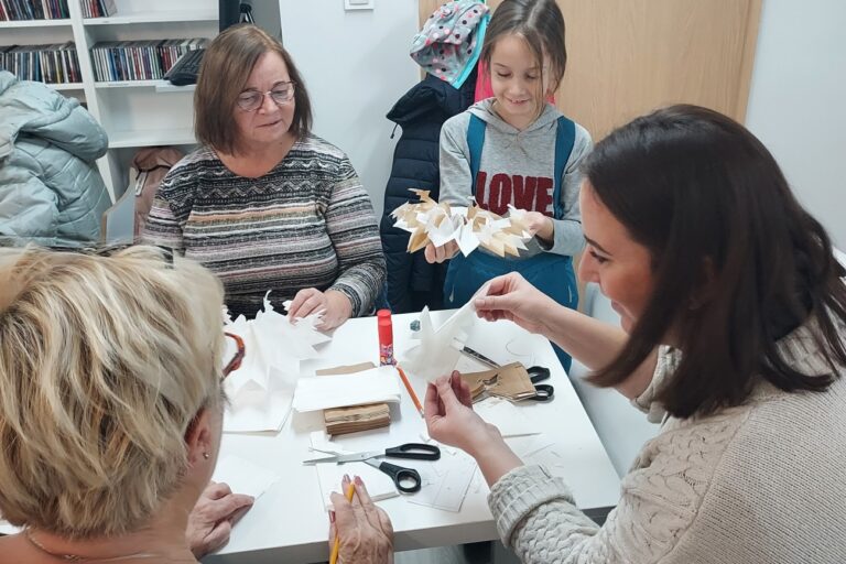 Uczestniczki przy pracy, dziewczynka już rozkłada papiery w gwiazdkę