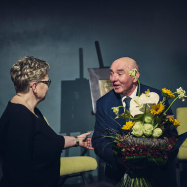 Prof. Krzysztof Nitsch otrzymuje gratulacje i kwiaty od zastępcy dyrektora MBP