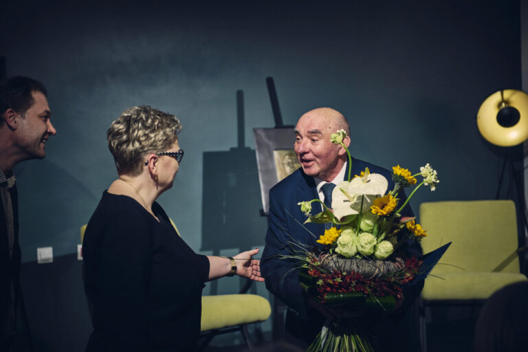Prof. Krzysztof Nitsch otrzymuje gratulacje i kwiaty od zastępcy dyrektora MBP