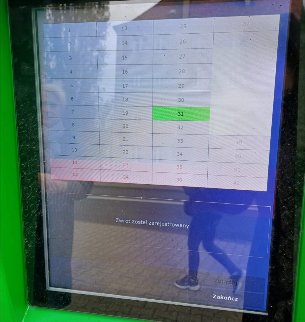 Na ekranie wyświetla rysunek poglądowy z numerem skrytki, zaznaczonym zielonym kolorem, i informacja "Zwrot został zarejestrowany"