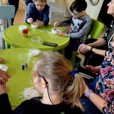 Dzieci z opiekunkami zaczynają robić zajęcie nad sztucznymi śniegami.
