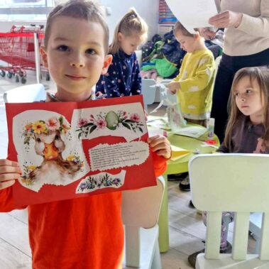 Chłopiec prezentuje swoją kartkę wielkanocną.