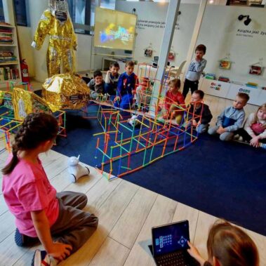 Robot poruszają się po konstrukcji bazy, jedna z dziewczyn steruje ich za pomocą konsoli