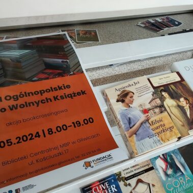 Na regale leżą plakat i książki