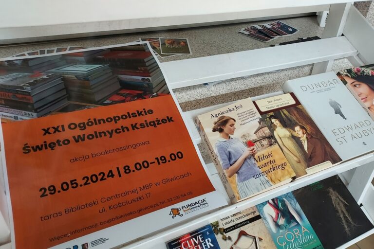 Na regale leżą plakat i książki