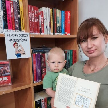 Pani z dzieckiem trzyma książkę