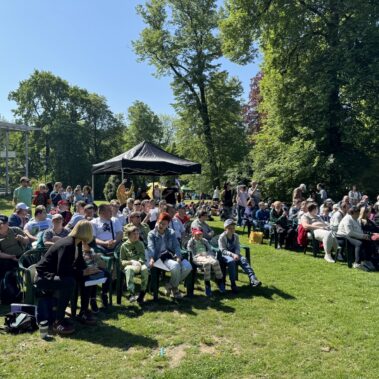 Uczestnicy siedzą na polowej widowni