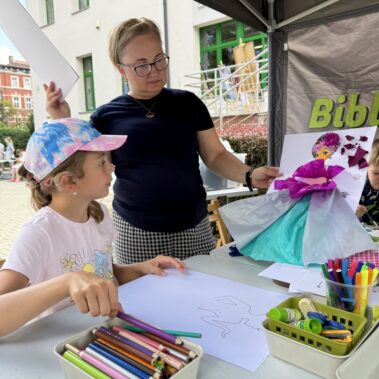 Bibliotekarka pokazuje dziewczynce przykłady prac