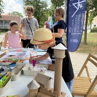 Model zamku z kartonu, w tle chłopiec rysuje