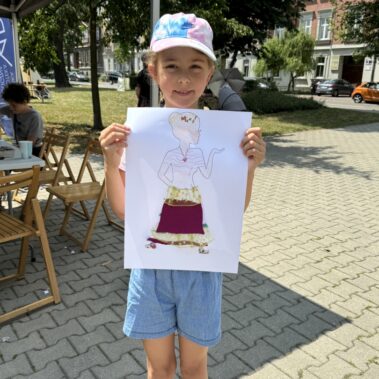 Dziewczynka prezentuje rysunek kobiety