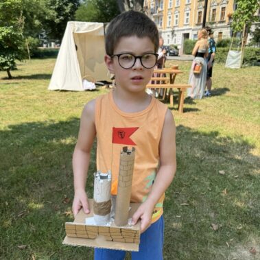 Chłopiec prezentuje model zamku z kartonu