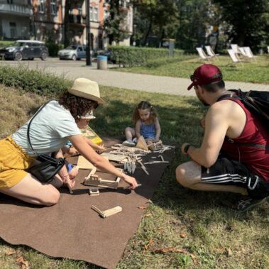 Uczestniczki z dziećmi budują model domu z drzewa