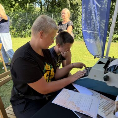 Chłopcy próbują pisać na maszynie do pisania