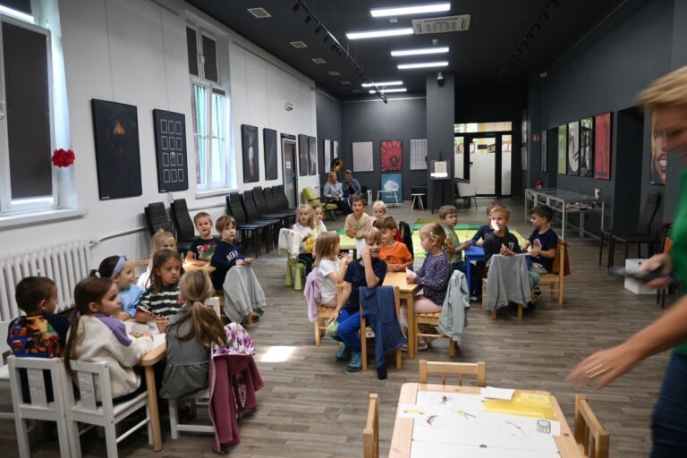 Widok na salę z dziećmi siedzącymi przy stolikach