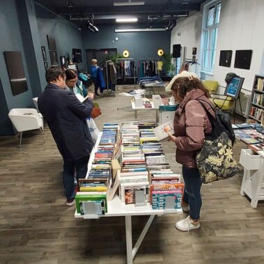 Widok ogólny na salę, goście przeglądają książki i ubrania