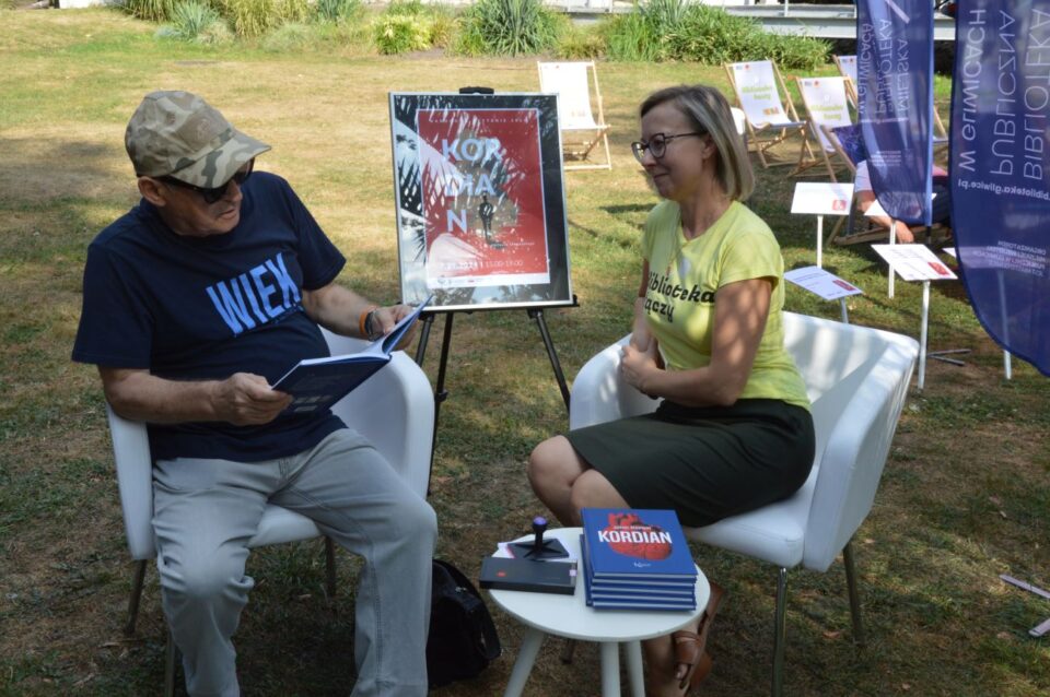 Pan czyta książkę w towarzystwie bibliotekarki