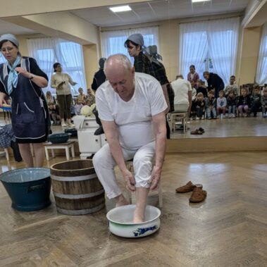 Pan przygotowuje do kiszenia kapust, najpierw myje nogi w misce