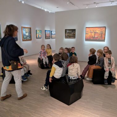 W galerii, pani przewodnik opowiada, dzieci słuchają
