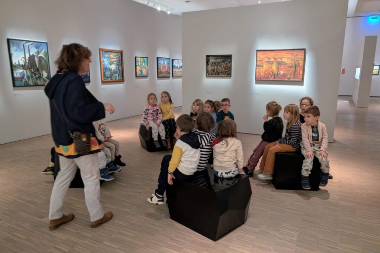 W galerii, pani przewodnik opowiada, dzieci słuchają