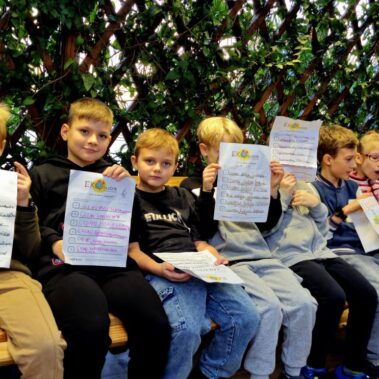 Uczestnicy pokazują kartki z własnymi zdaniami