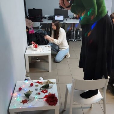 Pani stojąc na krześle robi zdjęcia dekorację na stoliku