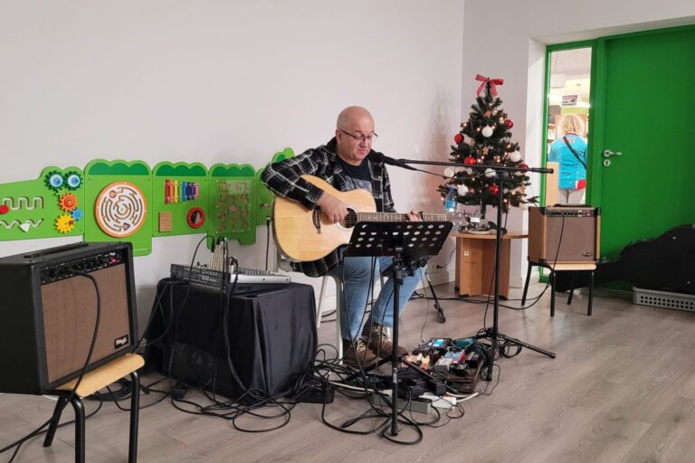 Artysta i muzyk Marek Biniek gra na gitarze