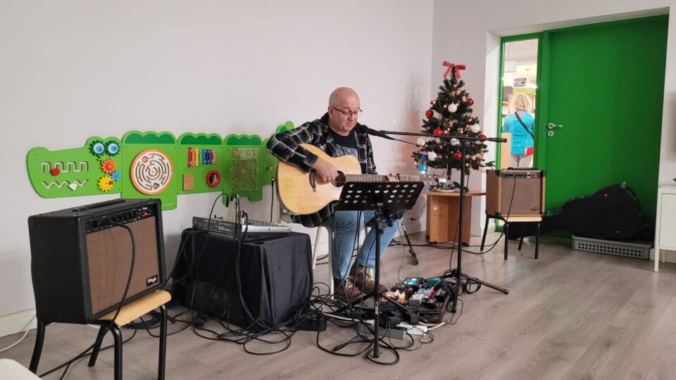 Artysta i muzyk Marek Biniek gra na gitarze