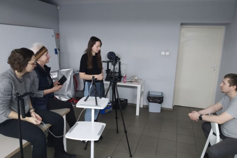 Uczestnicy dyskusją, model siedzi na krześle