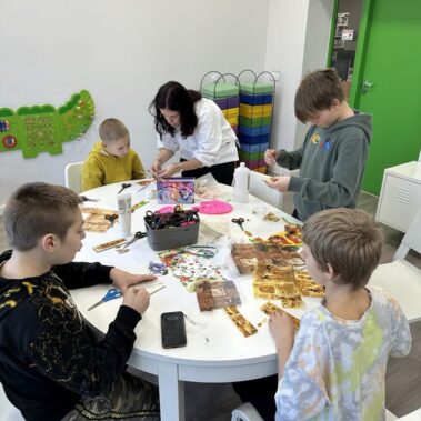 Chłopcy wykonują zakładki techniką decoupage