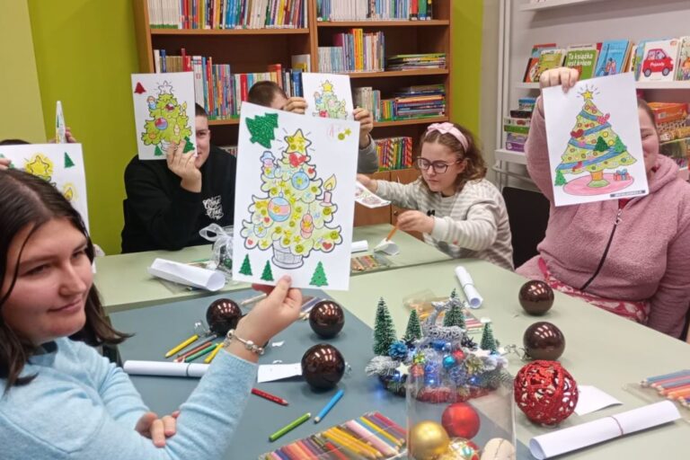 Dzieci pokazują swoje kolorowanki z motywem choinki