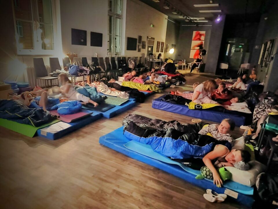 Dzieci leżąc na podłodze oglądają film