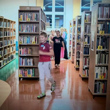 Dzieci chodzą po sali wypożyczalni