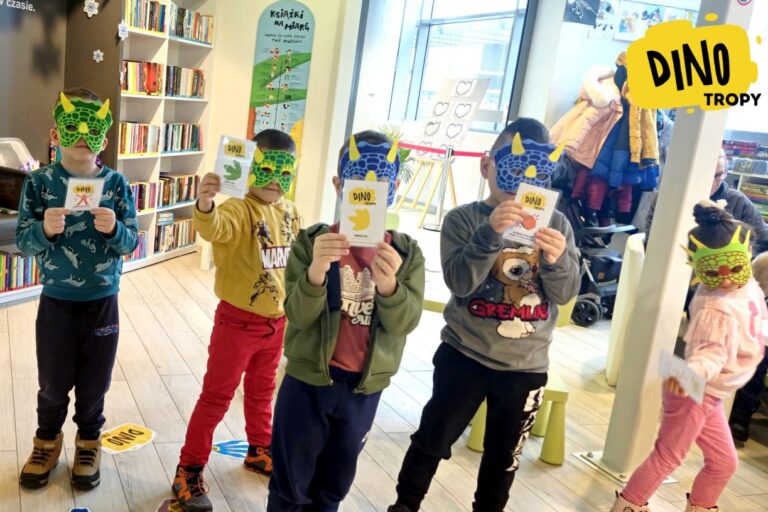 Dzieci w maskach dinozaurów prezentuje swoje kartki z wzorami tropów