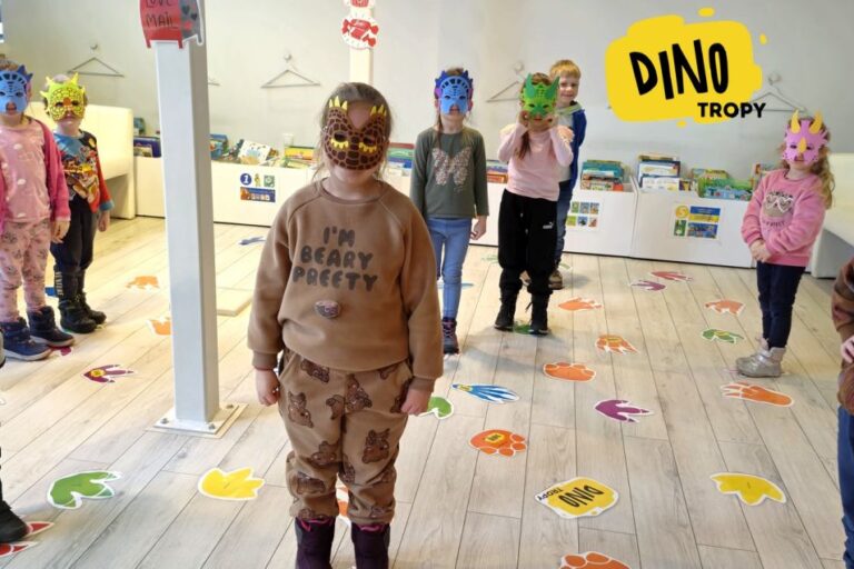 Dzieci w dino-maskach i stoją na tropach
