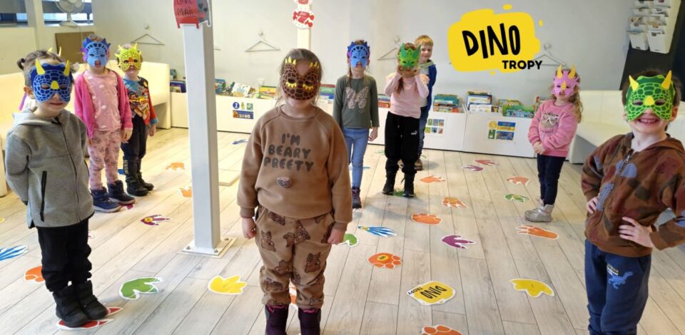Dzieci w dino-maskach i stoją na tropach
