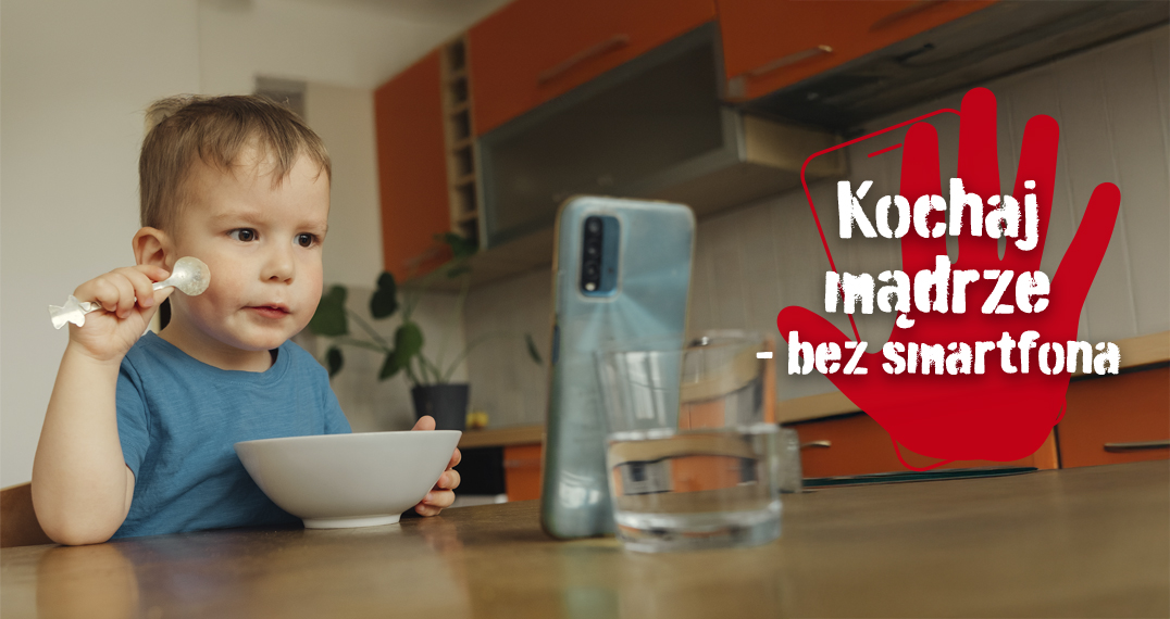 Baner Kampanii bez smartfona – chłopiec ogląda smartfona jedząc