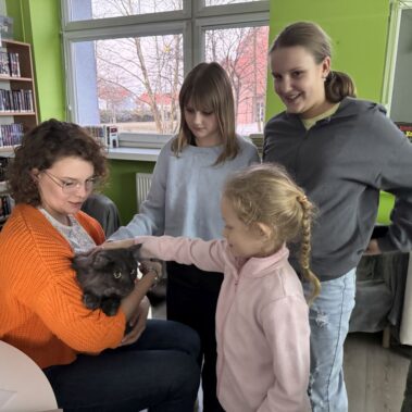 Katarzyna Łomazka i jej kot, dziewczynka go głaszcze, dzieci przyglądają